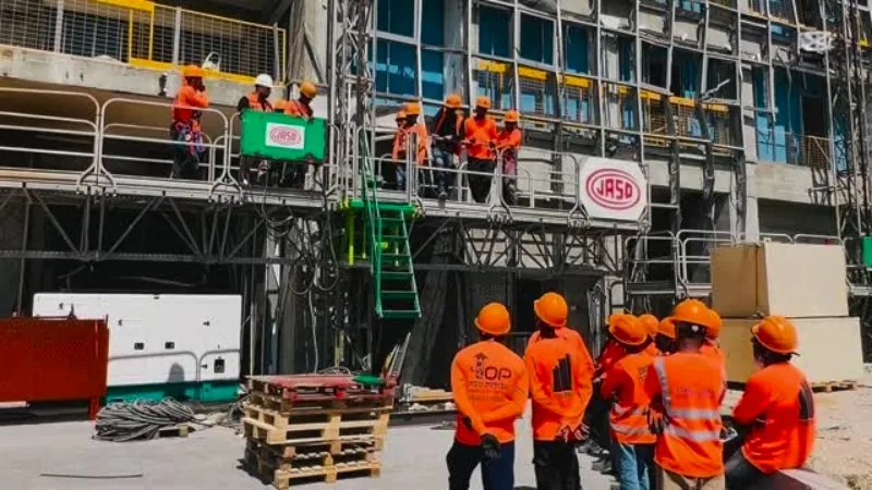 Workers in orange safety gear at an Israeli construction site